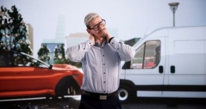 man clutching neck in pain standing near vehicles after car accident