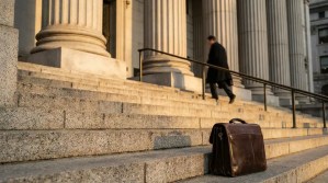 leather briefcase on courthouse steps with attorney ascending toward columns