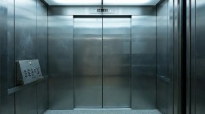 interior of elevator with closed metal doors and floor indicator displaying 14 and 15
