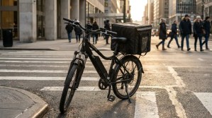 delivery e-bike with insulated cargo bag parked at urban crosswalk intersection